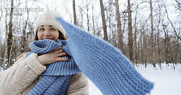 Junge Frau mit blauem Schal im Winterwald