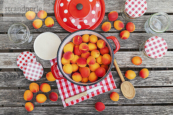 Preparation of apricot jam on wooden garden table