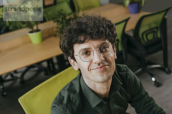 Lächelnder Geschäftsmann mit Brille im Büro