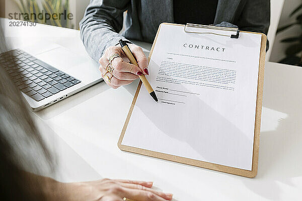 Geschäftsfrau und Kollegin unterzeichnen im Büro einen Vertrag