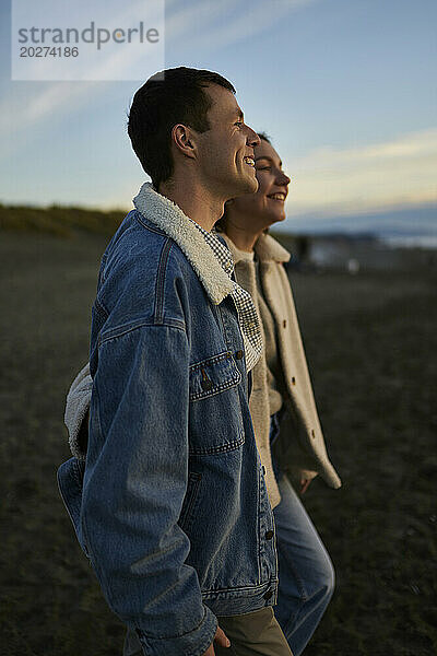 Lächelndes junges Paar genießt es am Meeresstrand