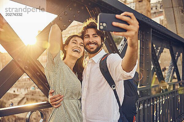 Fröhliches Paar macht ein Selfie mit dem Smartphone an der Dom-Luis-Brücke  Porto  Portugal