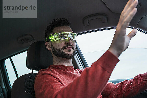 Mann mit Smart-Brille gestikuliert im Auto