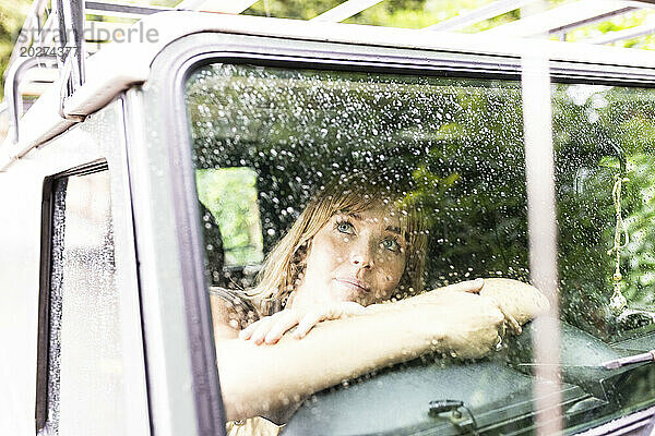 Frau sitzt und schaut durch das Autofenster