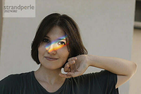 Rainbow colored light on woman's face