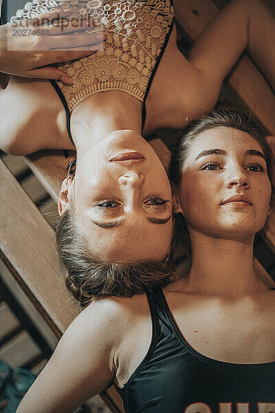 Young friends lying on bench at sauna