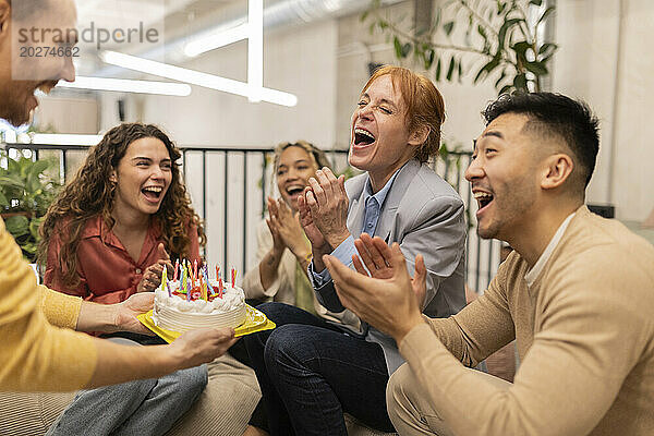 Fröhliche Geschäftskollegen feiern Geburtstag im Büro