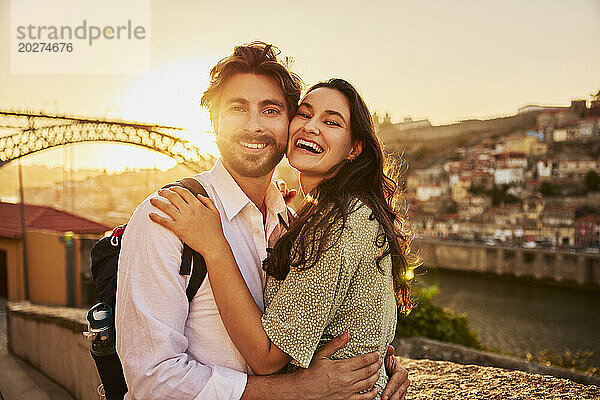 Liebevolles junges Paar vor der Dom-Luis-Brücke bei Sonnenuntergang  Porto  Portugal