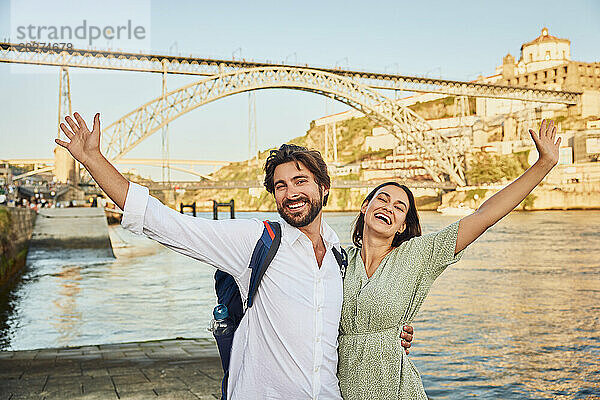 Cheerful couple enjoying near Douro river in front of Dom Luis bridge at Porto  Portugal