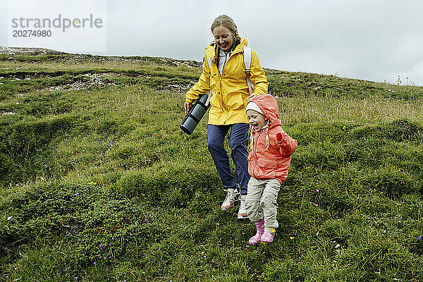 Glückliche Mutter und Tochter wandern auf dem Berg