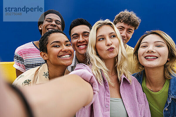 Lachende multiethnische Freunde machen Selfie