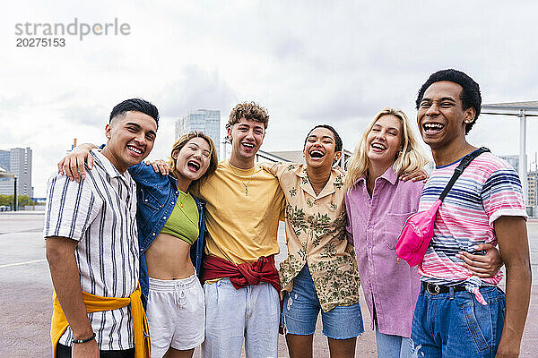 Gruppenfoto glücklicher junger Freunde in bunter Kleidung  die in die Kamera lächeln