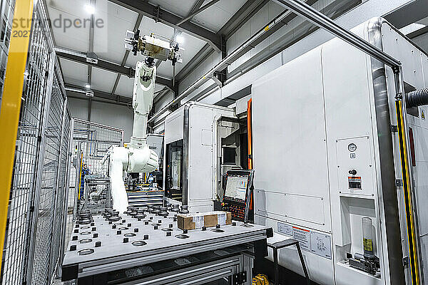 Roboterarm mit weißen Maschinen in der Fabrik