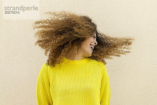 Verspielte Frau wirft Haare vor die Wand