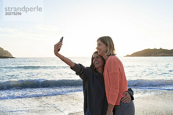 Sorglose Freunde machen gemeinsam ein Selfie am Strand