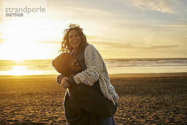 Glückliches junges Paar  das Spaß am Strand hat