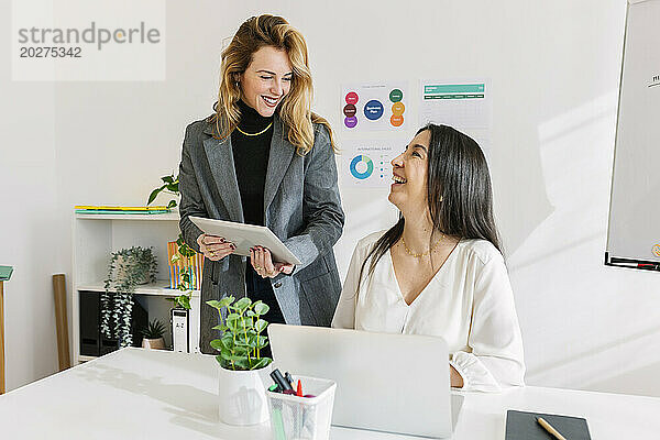 Glückliche Geschäftsfrauen  die im Büro zusammenarbeiten