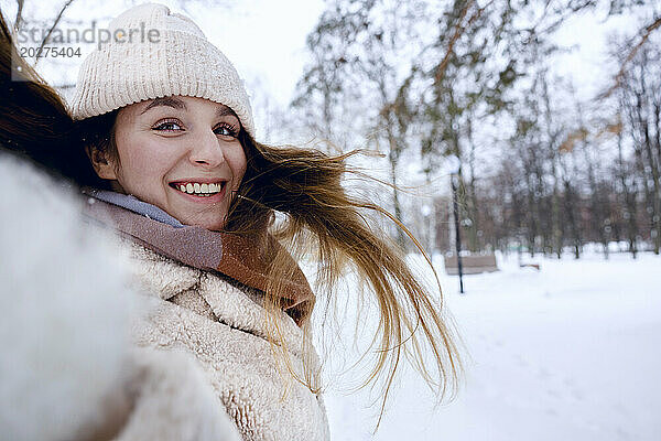 Glückliche junge Frau  die Spaß im Winterpark hat