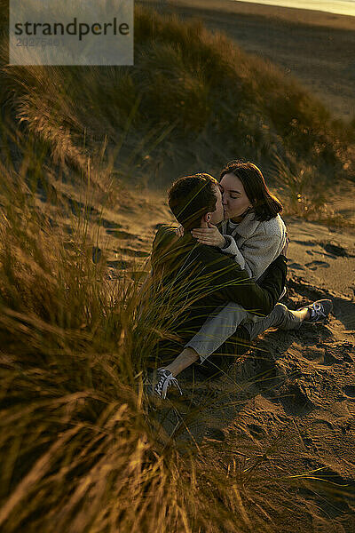 Junger Mann und Frau küssen sich am Strand