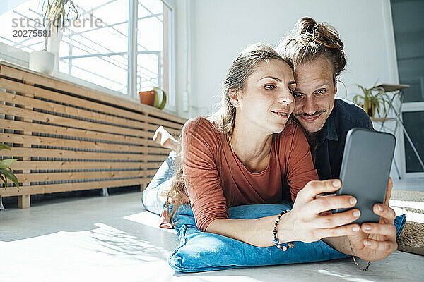 Glückliches Paar  das zu Hause ein Selfie mit dem Smartphone macht