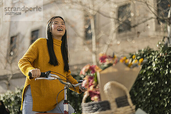 Cheerful woman with bicycle on sunny day