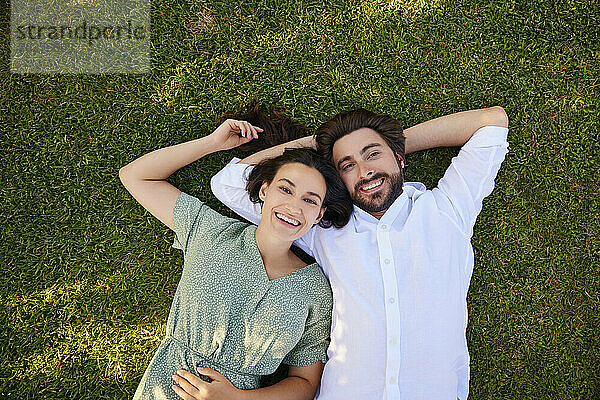 Happy couple lying together on grass