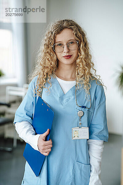 Doctor with curly hair wearing scrubs in hospital