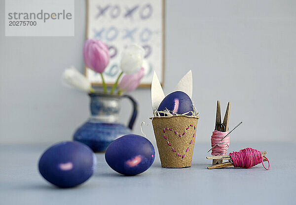 Studioaufnahme von lila Ostereiern und selbstgemachten Dekorationen