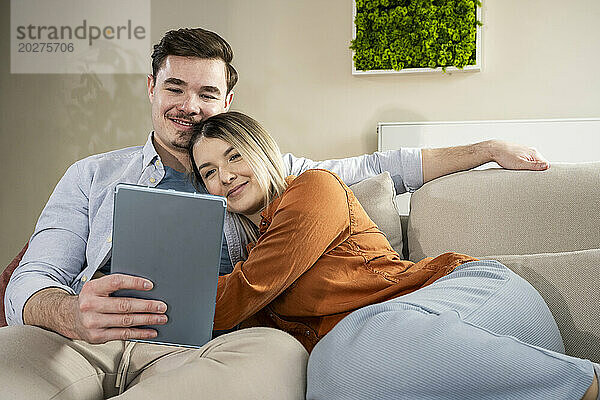 Liebevolles junges Paar nutzt Tablet-PC zu Hause
