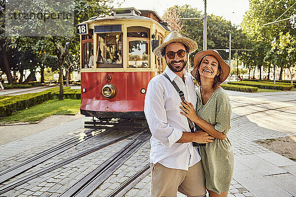 Glückliches Paar steht zusammen vor der Straßenbahn