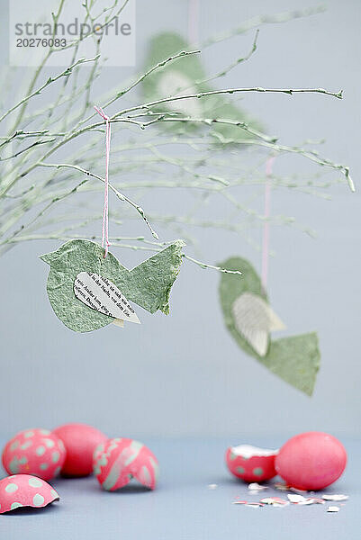 Cracked Easter eggs and twigs decorated with paper birds