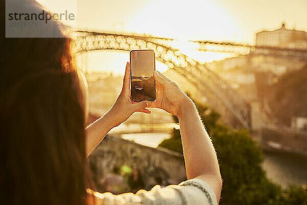 Frau fotografiert die Dom-Luis-Brücke per Smartphone in Porto  Portugal