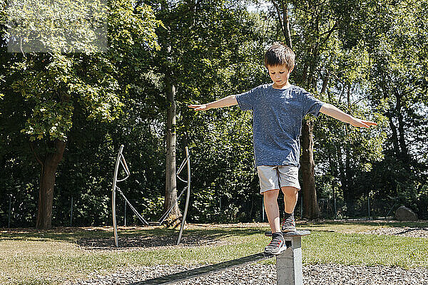 Boy balancing on metal structure in playground