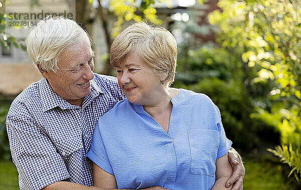 Glücklicher älterer Mann umarmt Frau im Garten