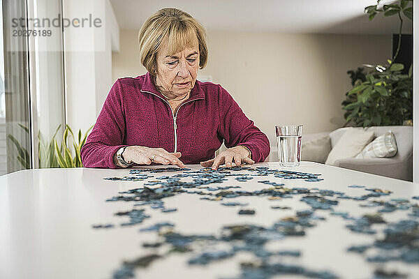 Ältere Frau spielt zu Hause Puzzle