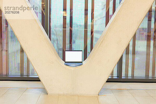 Laptop kept amidst architectural columns in office