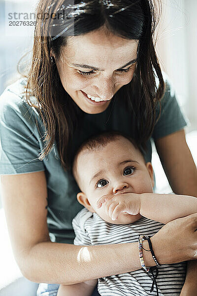 Smiling mother with baby girl at home