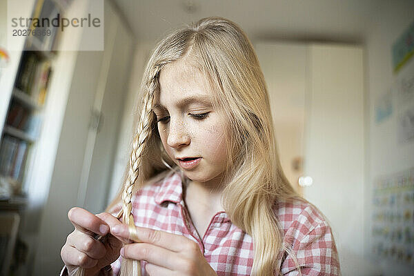 Girl braiding hair at home