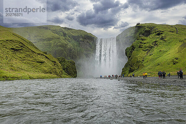 Island  Sudurland  Touristen besuchen den Wasserfall Skogafoss