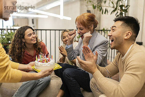 Glückliche Kollegen feiern Geburtstag mit Geschäftsfrau im Büro