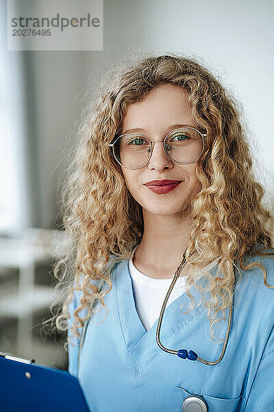 Lächelnder Arzt mit Brille in der Klinik