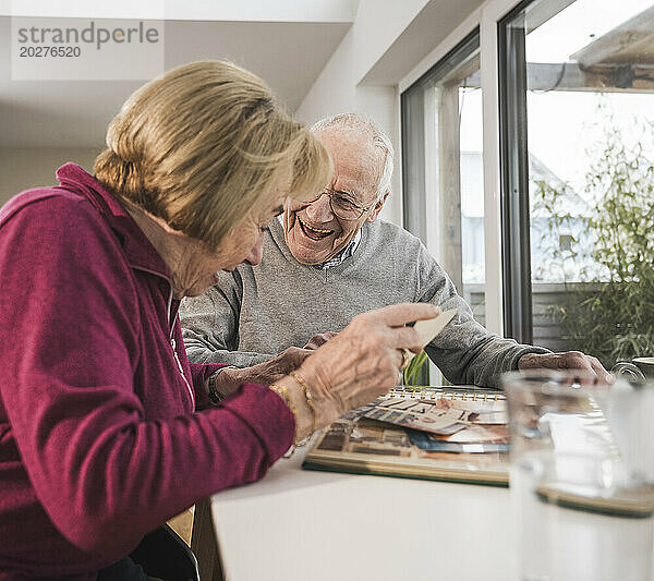 Glückliches älteres Paar  das sich zu Hause Fotos ansieht