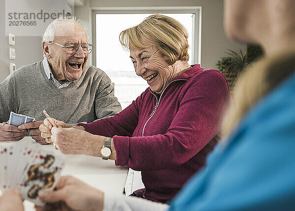 Glückliches älteres Paar  das zu Hause Karten spielt