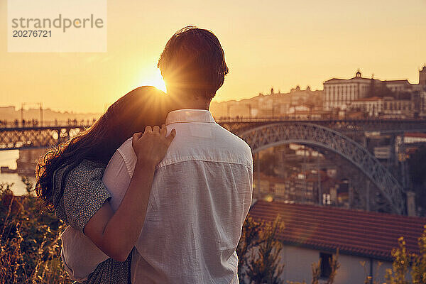 Liebespaar umarmt sich vor der Dom-Luis-Brücke bei Sonnenuntergang  Porto  Portugal