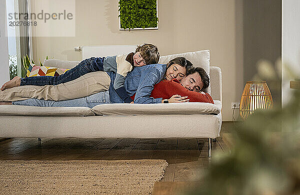 Happy family sleeping on sofa at home