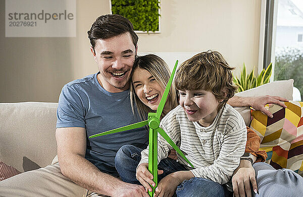 Glückliche Familie mit Windturbinenmodell zu Hause