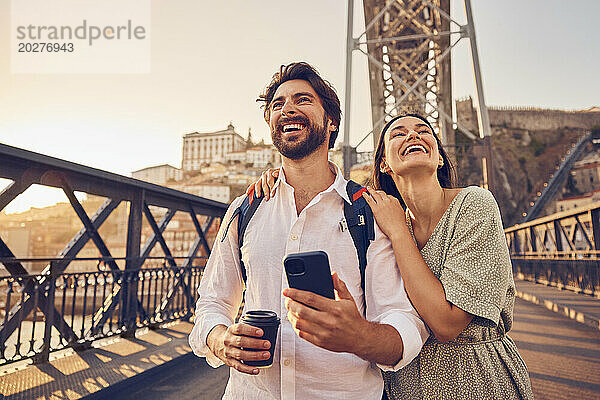 Fröhliches Paar  das Spaß auf der Dom-Luis-Brücke  Porto  Portugal hat