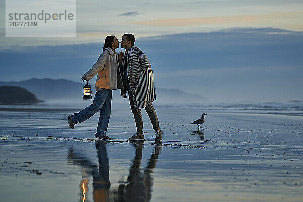 Young couple about to kiss at ocean beach