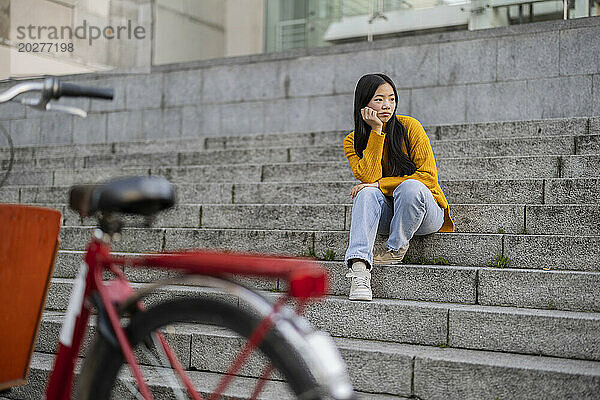 Traurige junge Frau sitzt auf Stufen