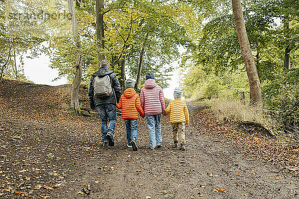 Vater und Kinder wandern durch den Herbstwald